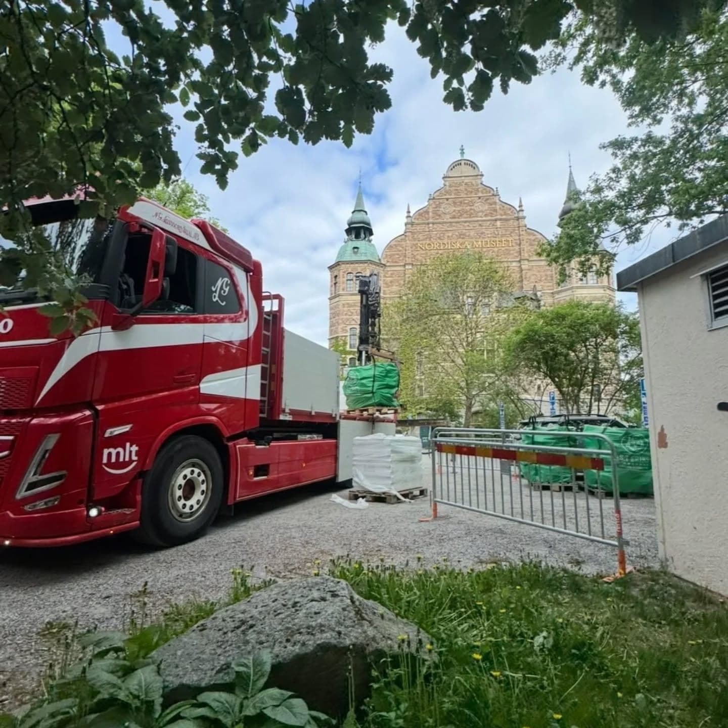 Lastbil med gatsten framför en kyrka