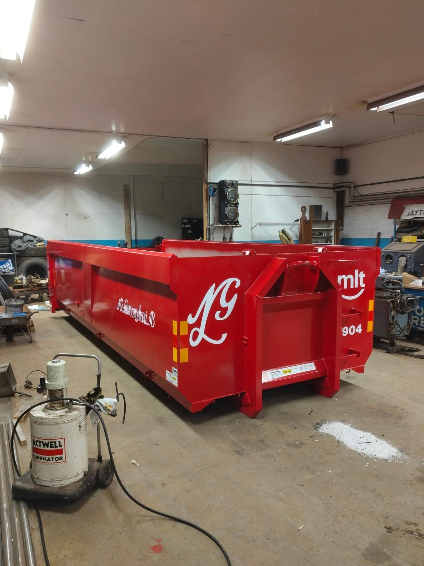 Nylackad röd container med åkeriets LG-monogram i verkstaden