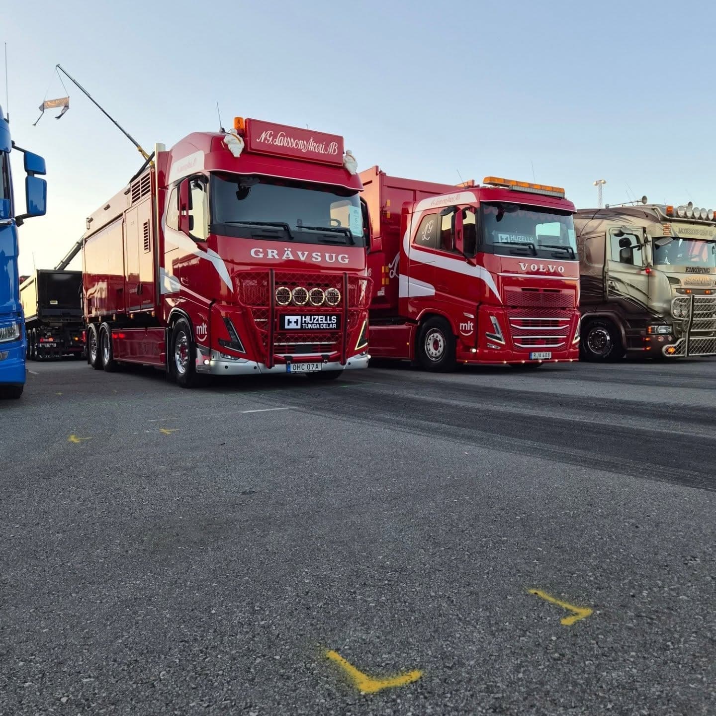 Grävsugen och en Volvo uppställda sida vid sida i kvällsljus
