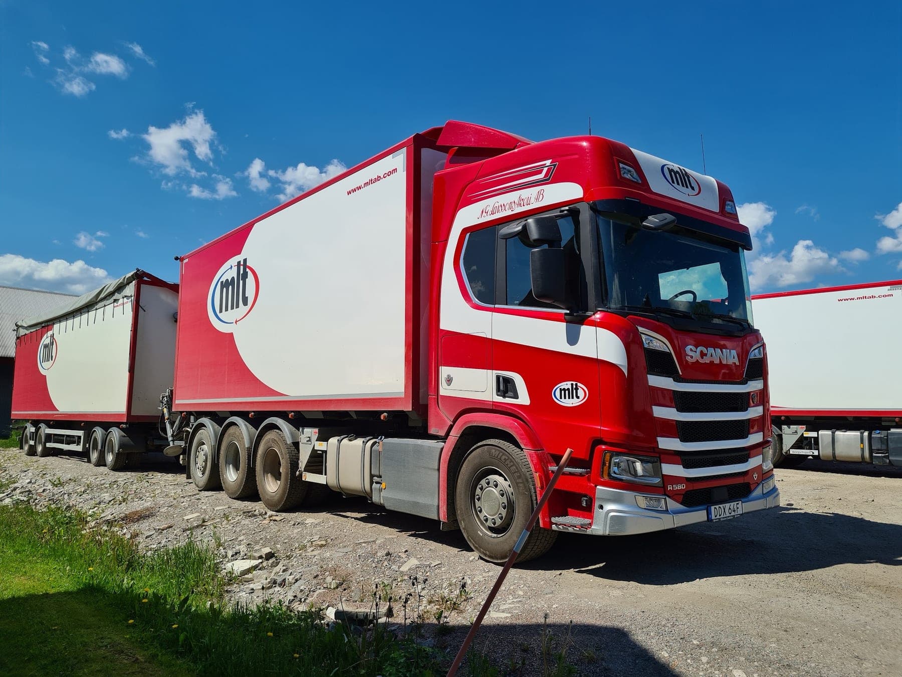 Scania R580 med släp i åkeriets röda och vita lack